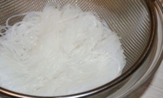 Воду из кастрюли с фунчозой необходимо слить через дуршлаг и переложить ее в глубокую тарелку;
